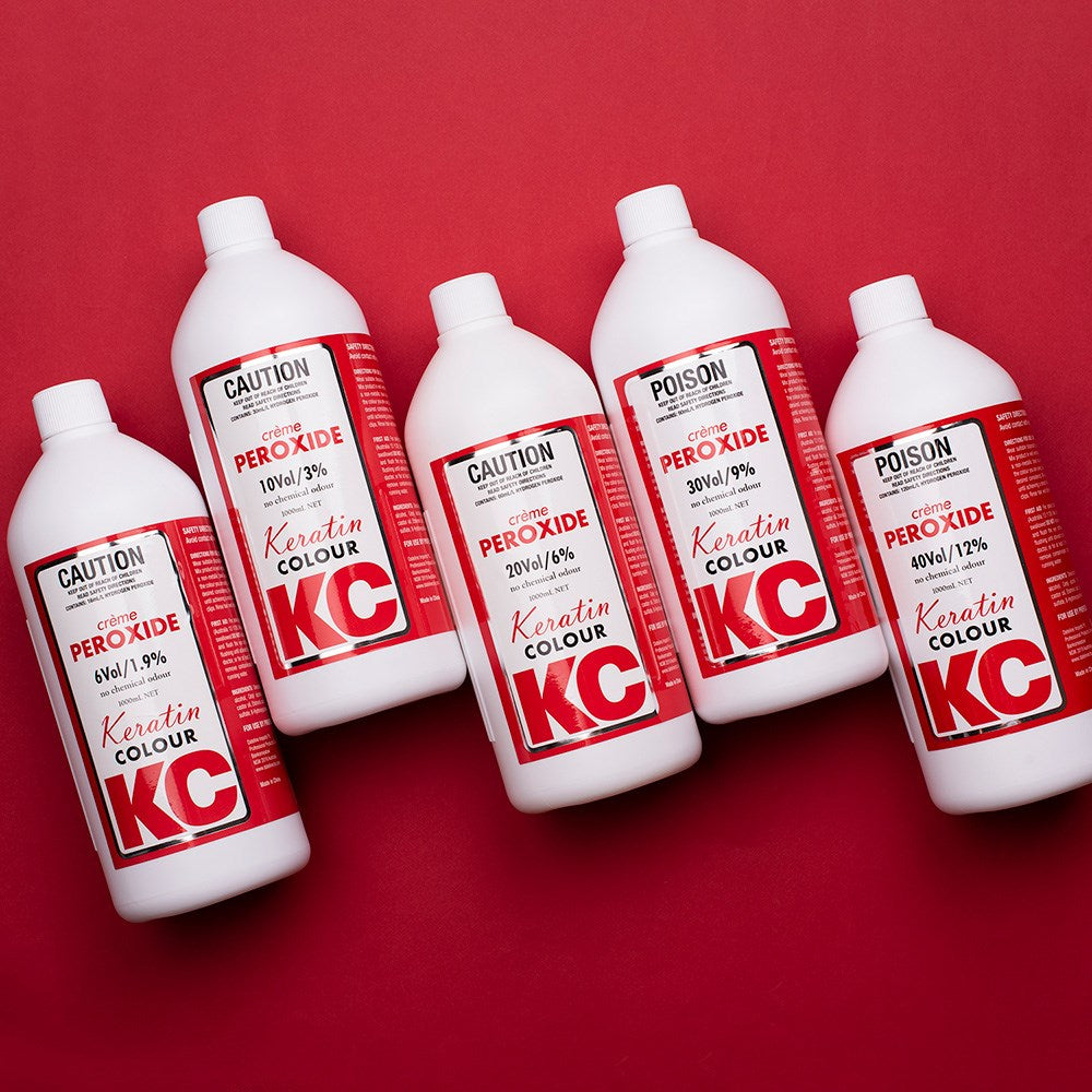 Five bottles of KC Peroxide on a red background