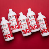 Five bottles of KC Peroxide on a red background